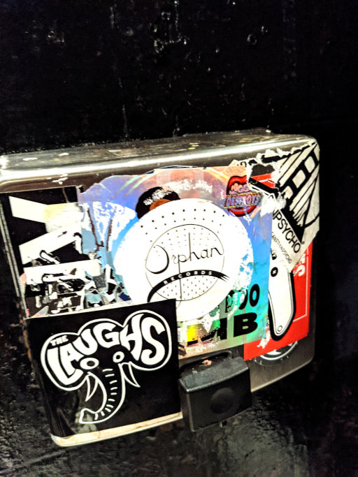 Laughs elephant sticker beside an Orphan Records sticker on a sticker-covered box
