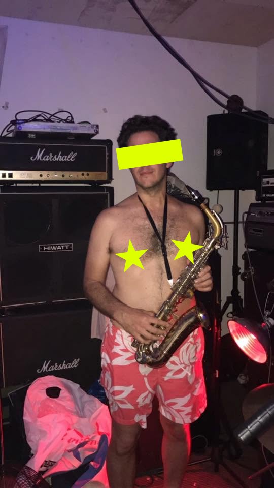 Band member posing with a saxophone in a practice room